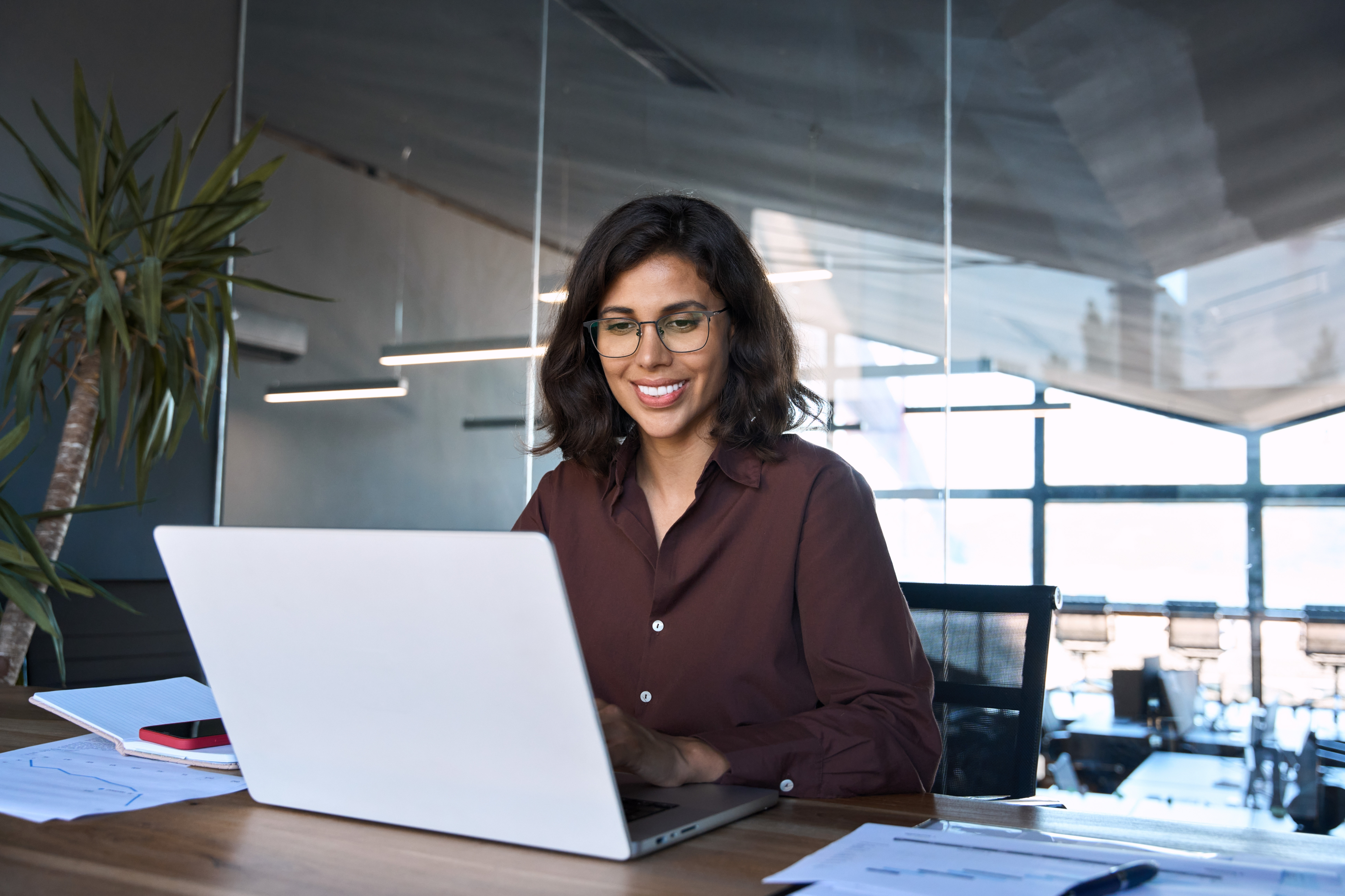 A smiling woman sitting at a laptop