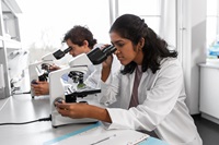 Scientists looking through microscopes