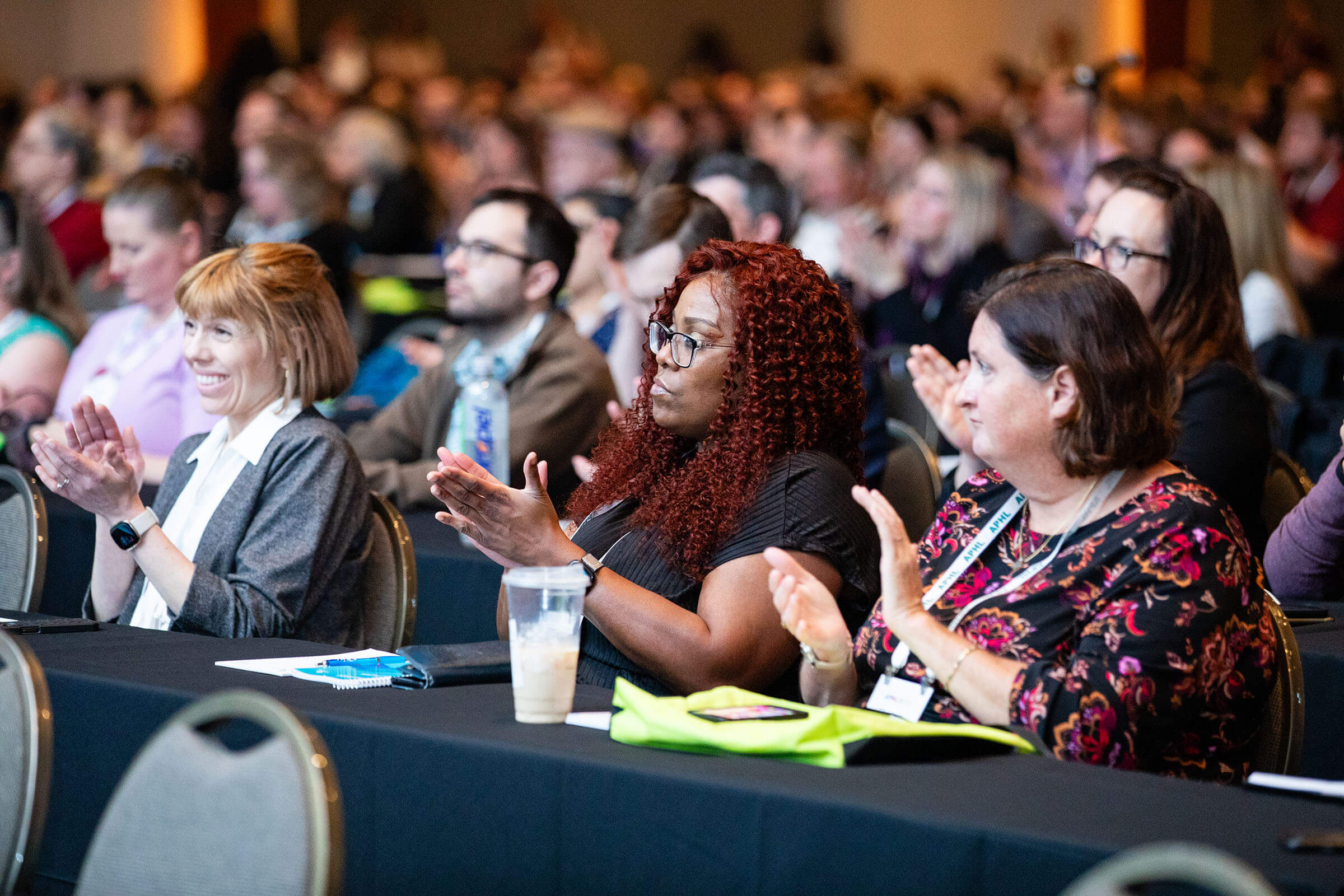 APHL Annual Conference attendees seated and clapping during a presentation.