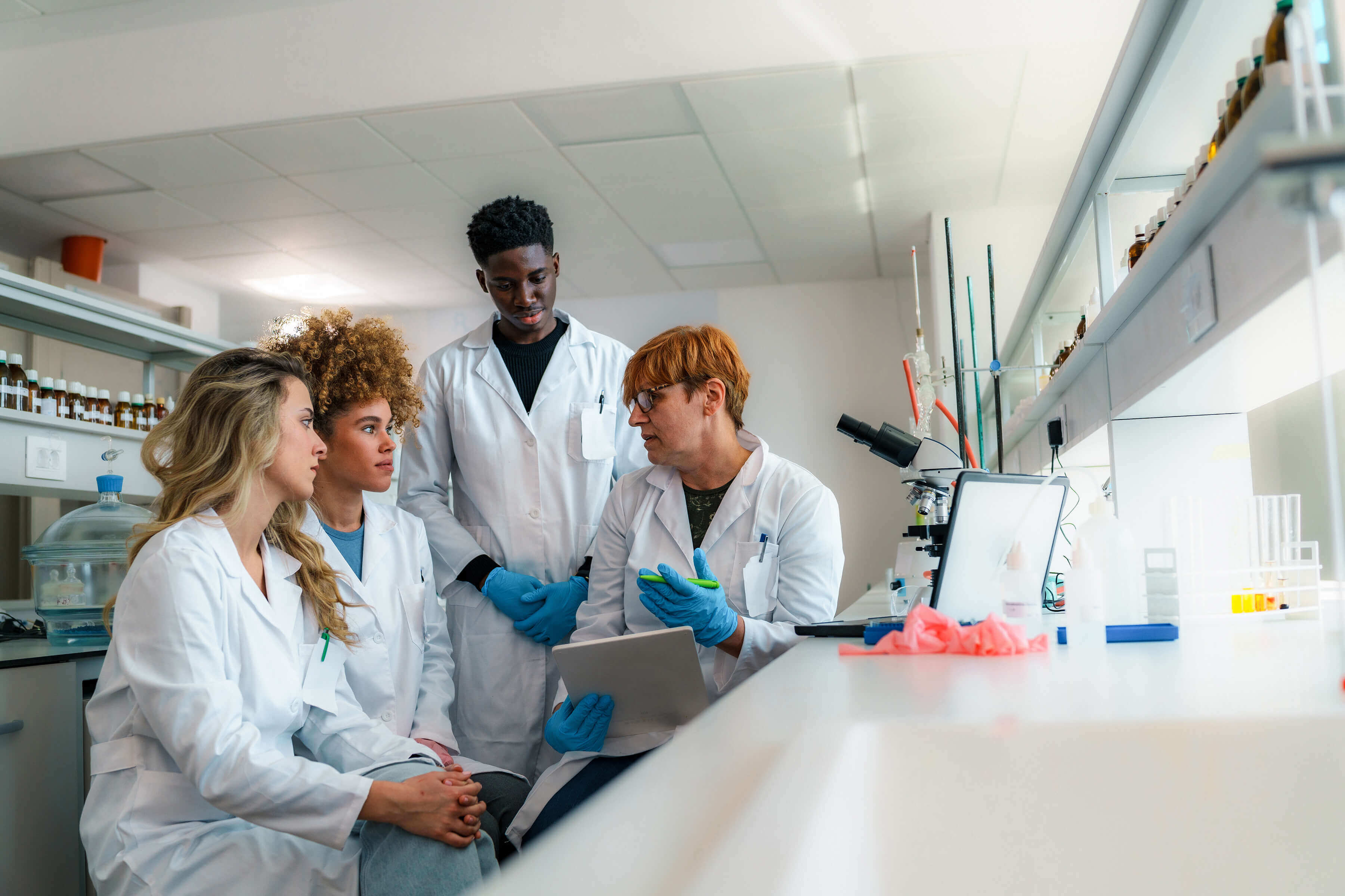 Laboratory instructor collaborating with a group of students