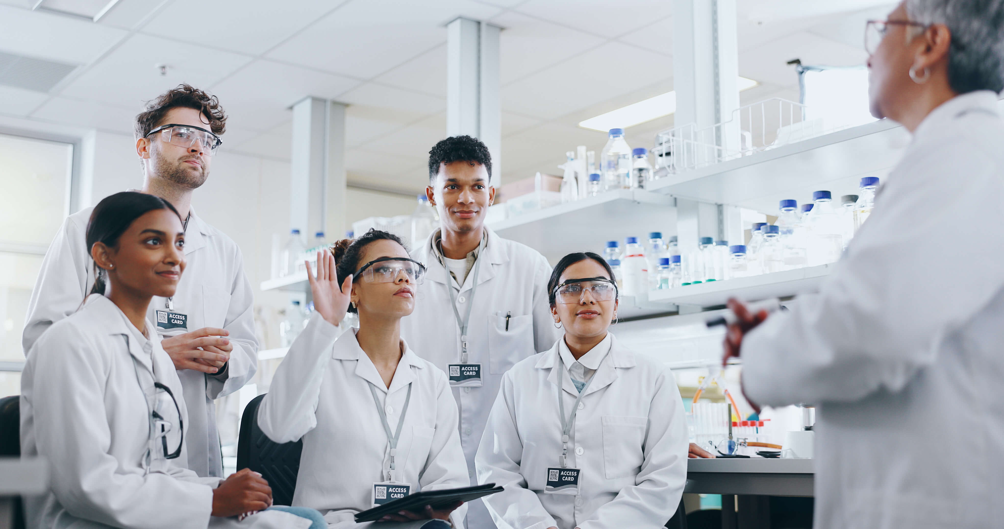 laboratory students listening to instructor and raising hand to ask a question