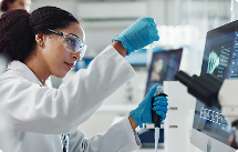 Scientist in front of computer with testing equipment